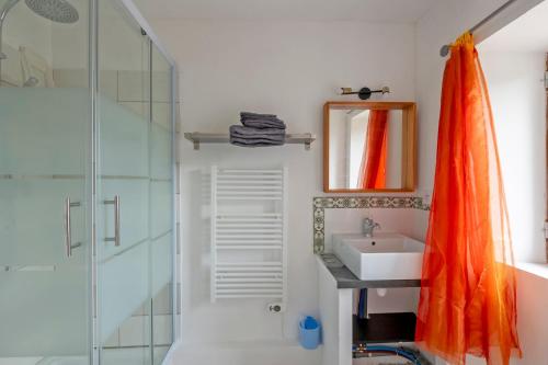 an orange shower curtain in a bathroom with a sink at Mazet Tornac in Tornac
