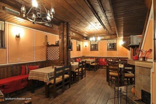 un ristorante con tavoli e sedie in una stanza di Gozbarov's Guest House a Koprivshtitsa