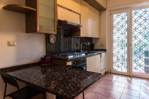 a kitchen with a counter top and a large window at Spazioso appartamento vicino EUR in Rome