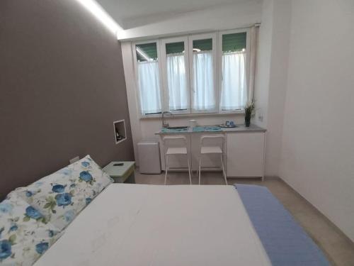 a bedroom with a bed and a desk and a window at Monolocale Versilia in Lido di Camaiore