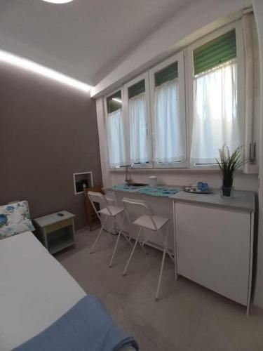 a bedroom with a bed and a desk and chairs at Monolocale Versilia in Lido di Camaiore