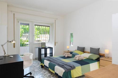 Schlafzimmer mit einem Bett, einem Schreibtisch und einem Fenster in der Unterkunft Spazioso appartamento vicino EUR in Rom