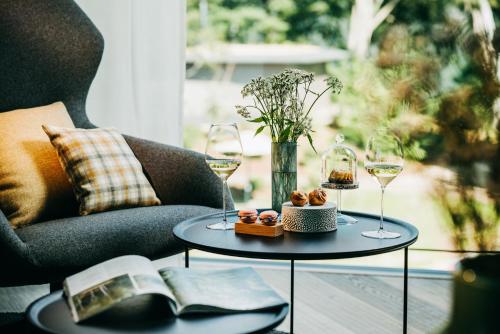 a table with two glasses of wine and a book at Luisenhöhe - Gesundheitsresort Schwarzwald in Horben