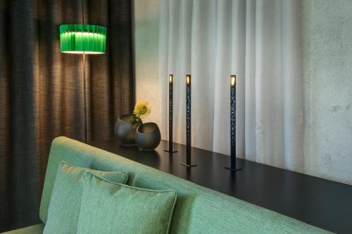 a living room with a couch and a table with a lamp at Das Royal in Bad Füssing