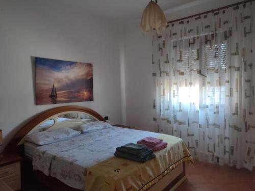 Schlafzimmer mit einem Bett und einem Fenster in der Unterkunft La villa al mare in Durrës