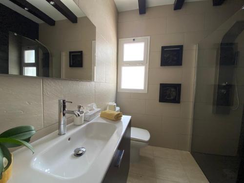 a bathroom with a sink and a toilet and a mirror at MiVida in San Bartolomé