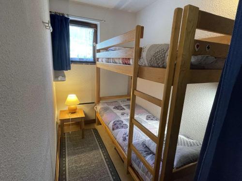 a room with three bunk beds and a lamp at Appartement Praz-sur-Arly, 2 pièces, 4 personnes - FR-1-603-39 in Praz-sur-Arly