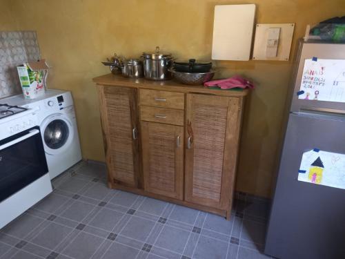 a kitchen with a stove and a refrigerator at Sénégal CASAMANCE in Boukot Ouolof