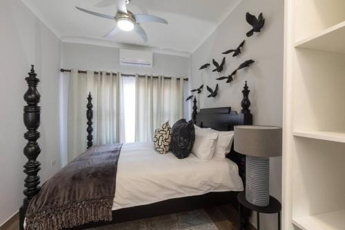 a bedroom with a bed with birds on the wall at One More Night Apartment E203 in Gaborone