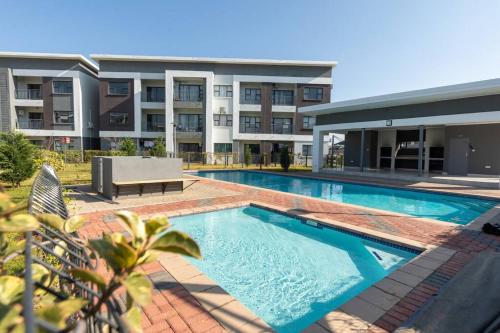 a swimming pool in front of a building at One More Night Apartment E203 in Gaborone