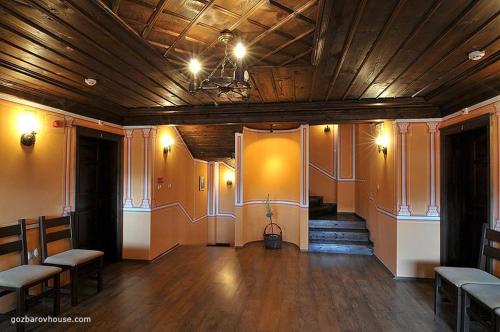 Habitación grande con techo de madera y suelo de madera. en Gozbarov's Guest House en Koprivshtitsa