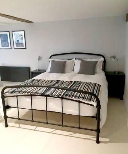 a bedroom with a large bed with white walls at Studio at Church House in Bideford