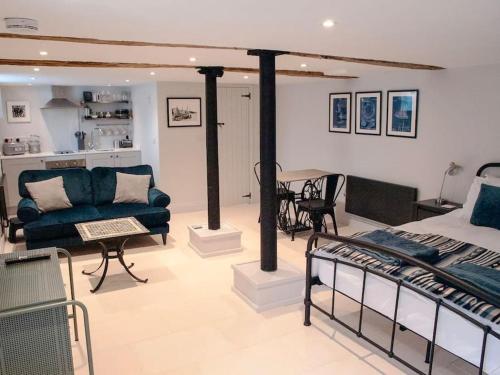 salon z niebieską kanapą i łóżkiem w obiekcie Studio at Church House w mieście Bideford