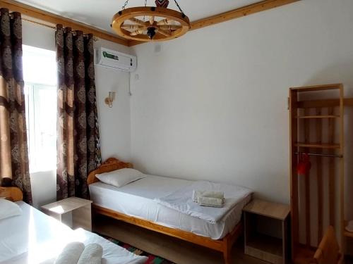 ein kleines Schlafzimmer mit 2 Betten und einem Fenster in der Unterkunft NAZIRA Boutique Hotel in Xiva