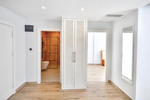 un couloir blanc avec une porte menant à une salle de bains. dans l'établissement Bliss Suites & Hotel, à Fethiye