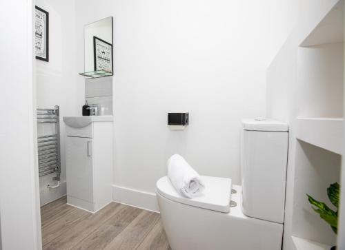 a white bathroom with a toilet and a sink at Stylish Stay Near The Stadium Walk To The Action in Liverpool