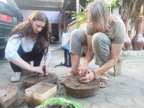 two women are playing with clay on a wheel at Bunga Maliq Bungalow Lombok in Tetebatu