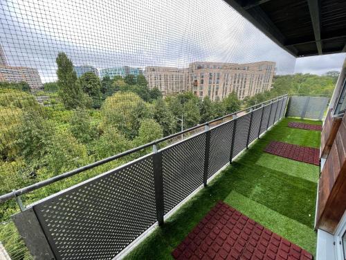 een balkon met een hek en groen gras en gebouwen bij Executive Luxury 2 Bedroom Apartment - With underground parking in Londen