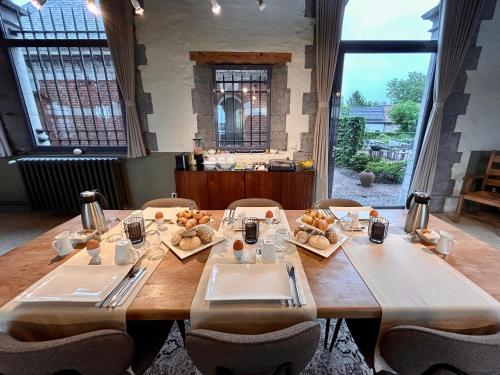 a large wooden table in a room with tables and chairs at B&B Tolkantoor in Zelzate