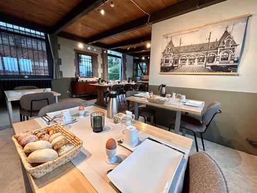 a dining room with a table with a basket of bread at B&B Tolkantoor in Zelzate