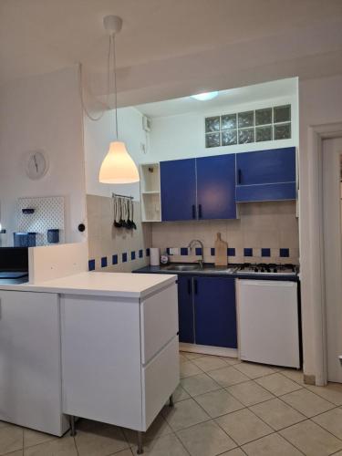 een keuken met blauwe kasten en een wit aanrecht bij Casa Mon Amour Livorno in Livorno