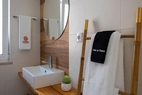 a bathroom with a sink and a mirror at Coral Boutique Suites in Albufeira