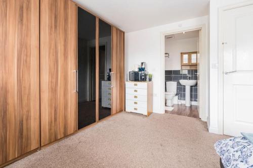a bathroom with a large wooden closet in a room at En-suit room with free dedicated parking in Manchester