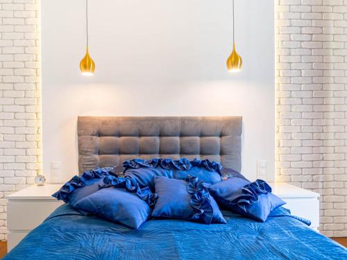 a large blue bed with blue pillows on it at Apartament Sukiennicza in Kraków