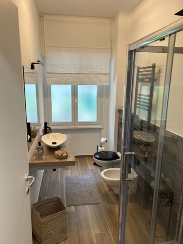een badkamer met een glazen douche en een wastafel bij MariGiu in Rapallo