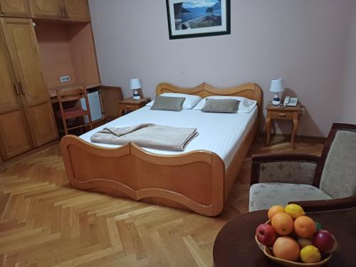 a bedroom with a bed and a bowl of fruit on a table at Accommodation Marija 2 in Kotor