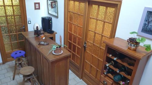 a room with a wooden door and a table with wine bottles at Verdure tourangelle in Azay-sur-Cher