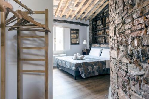 a bedroom with a bed and a brick wall at 31 steps to Heaven - Heart of Lucca in Lucca