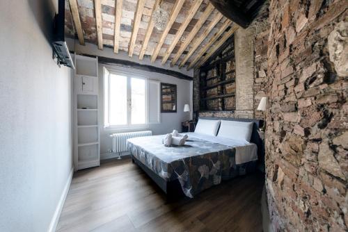 a bedroom with a bed and a brick wall at 31 steps to Heaven - Heart of Lucca in Lucca