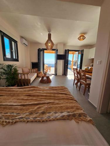 a bedroom with a large bed and a living room at Byblos Cycladic House in Vívlos