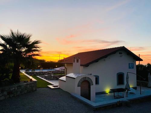 a small white house with a sunset in the background at Relaxing Villa Cefalù - Private Pool & Beach Walk by flAle's in Cefalù