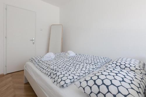 um quarto branco com uma cama com um edredão branco em Miramare em Zagreb