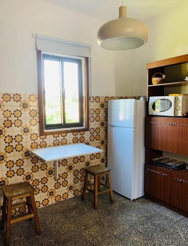 a kitchen with a white refrigerator and a window at Grandma's Carolina Villa in Sul