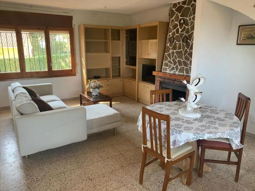 een woonkamer met een witte bank en een tafel bij Costa Brava Home in Terra Brava