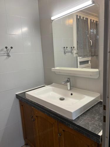 La salle de bains est pourvue d'un lavabo blanc et d'un miroir. dans l'établissement Petite maison en bordure de N7, à Piolenc
