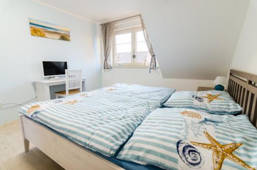 Schlafzimmer mit einem Bett mit blauer und weißer Bettwäsche in der Unterkunft Guesthouse SaM in Roudnice nad Labem