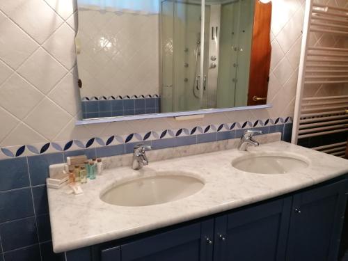a bathroom with two sinks and a mirror at Casa Clelia - Sulla strada per il lago in Rezzato