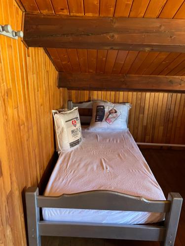 a small bed in a wooden room with avertisementatronatronstrationstrationstrationstration at Petite maison en bordure de N7 in Piolenc