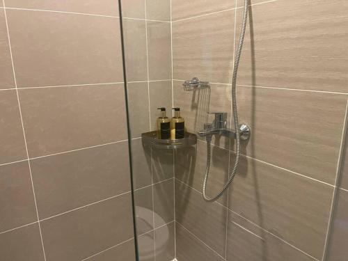 a bathroom with a shower with two bottles in it at Stylish 1BR Uptown Parksuites BGC, 200mbps/SmartTv in Manila