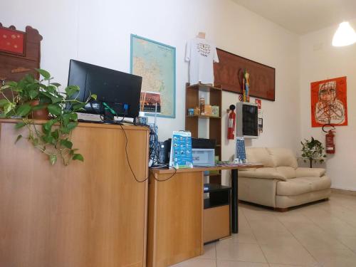 a living room with a desk with a computer on top at Hotel La Pineta in Arborea