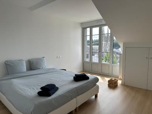 une chambre avec un grand lit avec deux serviettes dessus dans l'établissement Le duplex Saint-Corentin - Hyper Centre - Parking Privé, à Quimper