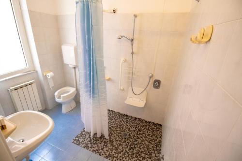 uma casa de banho com um chuveiro, um WC e um lavatório. em Hotel Corallo em Pietra Ligure