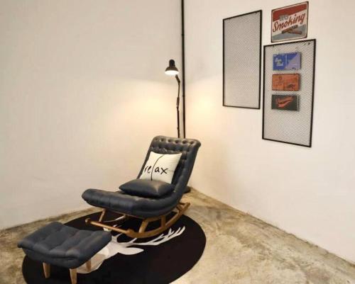 a reclining chair and a lamp in a room at Studio S Conceptual Homestay Station 18 - Ipoh in Ipoh
