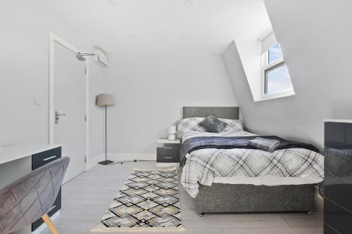 um pequeno quarto com uma cama e uma janela em Private Spacious En-suite room em Londres