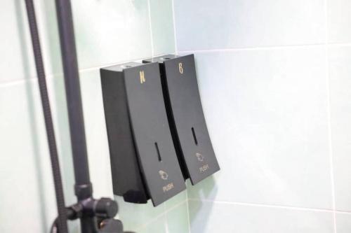 a black object on a wall with a lightswitch at Studio S Conceptual Homestay Station 18 - Ipoh in Ipoh