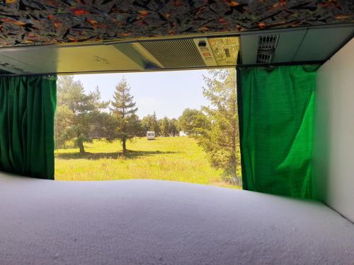 een kamer met een raam met uitzicht op een veld bij Kapsuły Sypialne AutokarSingliPL, Par, ciekawe miejsce in Władysławowo